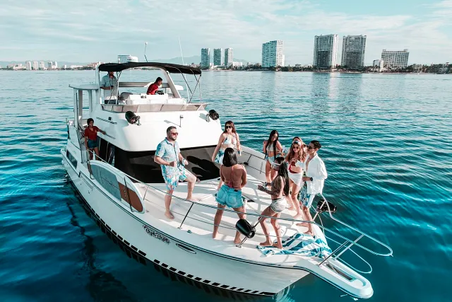 Guests on a yacht with the Puerto Vallarta hotel zone behind