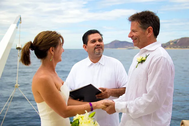 A newly married couple on the bow of a yacht